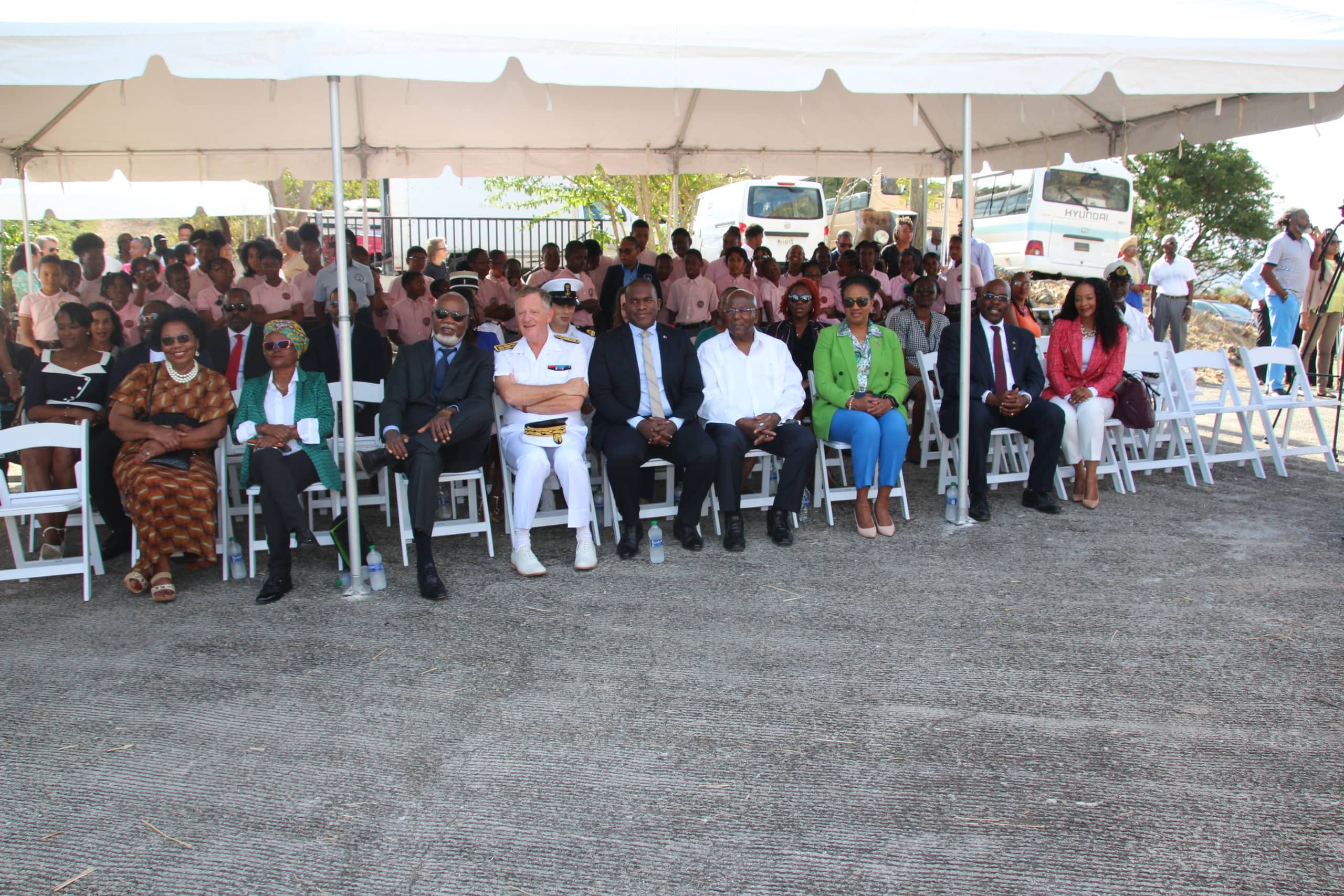 Visitors to the anniversary celebration of the Treaty of Concordia listen to the speech by the Governor of Sint Maarten while seated under a tent.