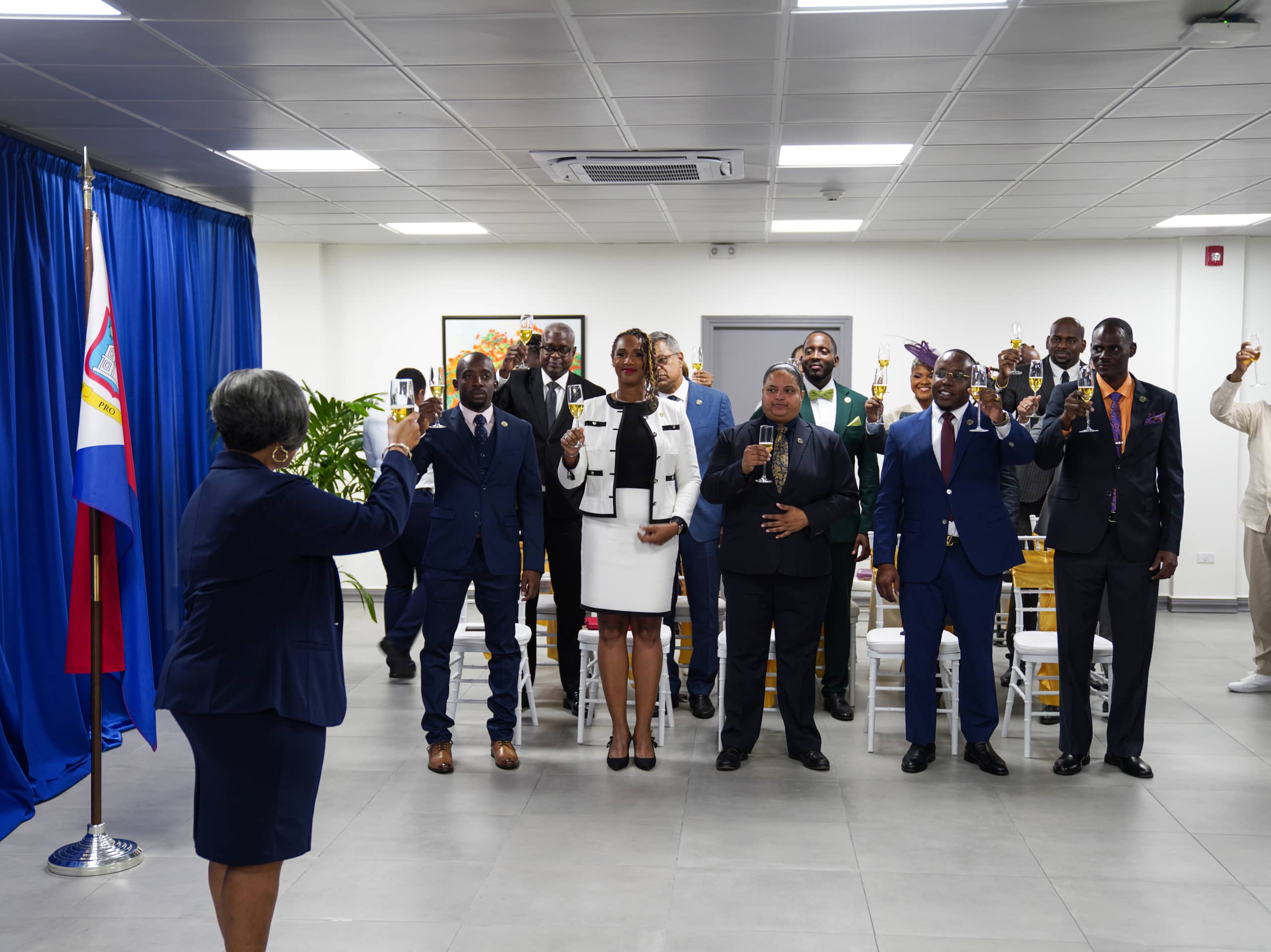 In this photo, the Acting Governor of Sint Maarten and the newly sworn-in Members of Parliament raise a glass during the swearing-in ceremony.